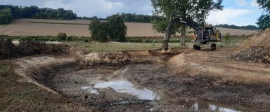 Pelle mécanique façonnant un bras de rivière avant sa mise en eau